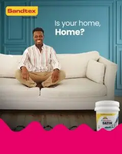 A design banner for Sandtex, A man is sitting in a relaxing home and smiling. The copy on the banner says: Is your home, home?